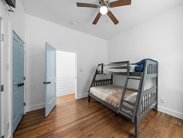 bedroom with a ceiling fan, baseboards, and wood finished floors