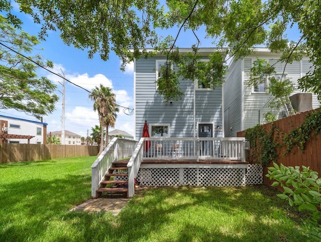 rear view of property with a yard, a fenced backyard, and a wooden deck