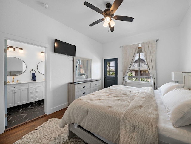 bedroom featuring connected bathroom, baseboards, dark wood-type flooring, and ceiling fan