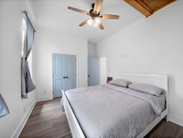 bedroom with dark wood finished floors, a ceiling fan, baseboards, and a closet