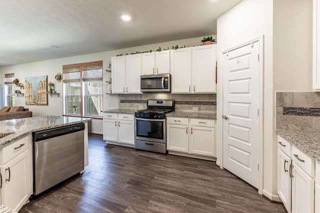 kitchen with appliances with stainless steel finishes, white cabinetry, backsplash, dark wood-style floors, and recessed lighting