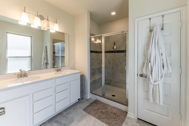 bathroom with a stall shower, double vanity, and recessed lighting