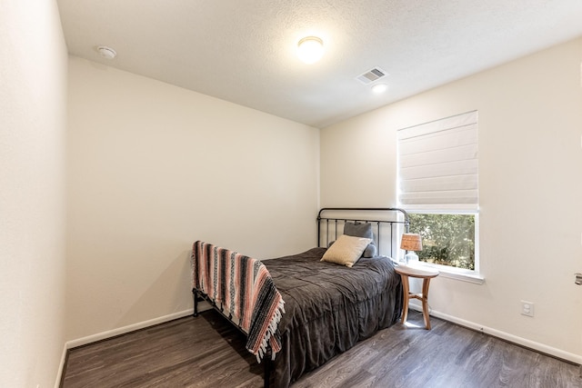 bedroom with wood finished floors and baseboards