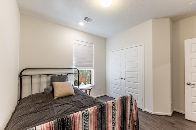 bedroom featuring dark wood-style flooring, baseboards, a closet, and recessed lighting