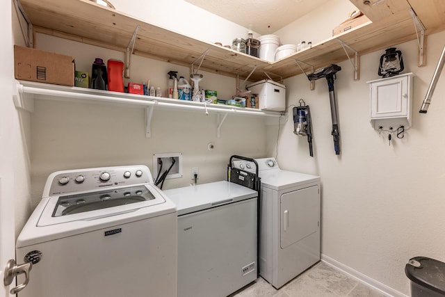 laundry room featuring washing machine and dryer and baseboards