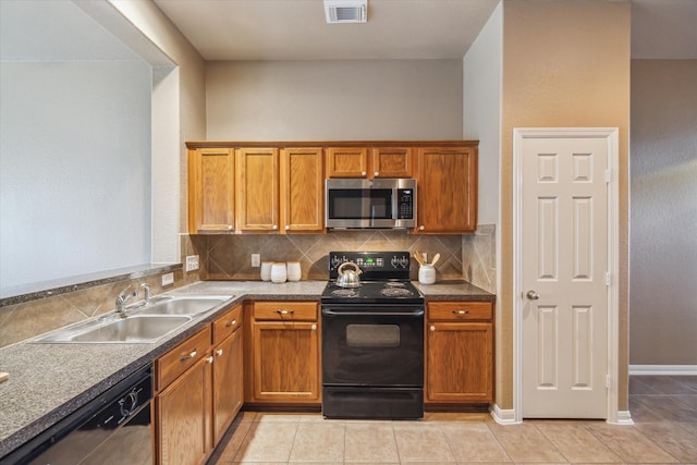 kitchen with visible vents, black appliances, a sink, brown cabinetry, and decorative backsplash