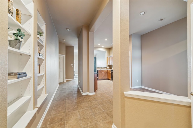 hall with built in features, recessed lighting, and baseboards