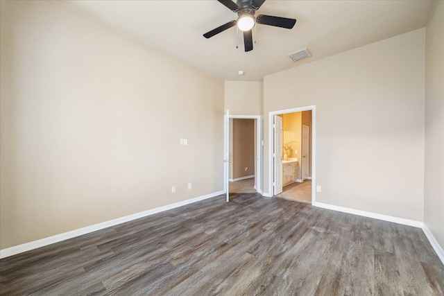 unfurnished bedroom with visible vents, wood finished floors, connected bathroom, baseboards, and ceiling fan