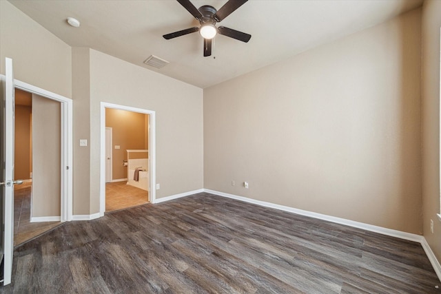 unfurnished bedroom featuring visible vents, baseboards, connected bathroom, and dark wood-style flooring