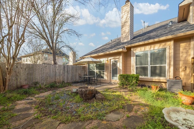 back of property featuring a patio, central air condition unit, fence, and a chimney