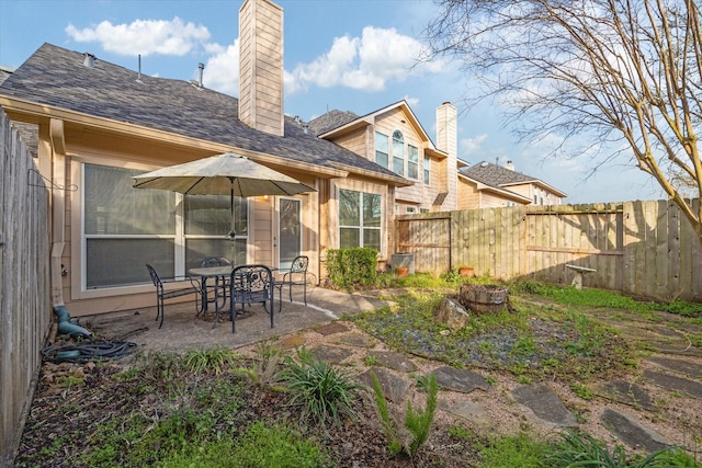 rear view of property with a patio area, a chimney, and fence