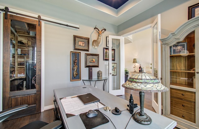 office featuring a barn door and dark wood-style flooring