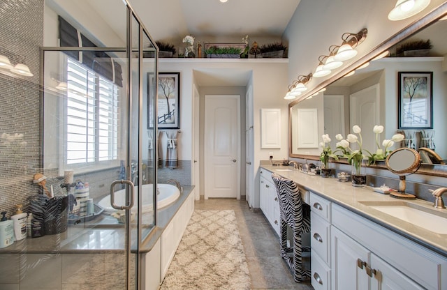 bathroom with double vanity, a garden tub, a shower stall, and a sink