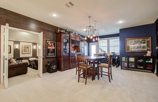 dining area featuring recessed lighting, visible vents, light colored carpet, and wood walls