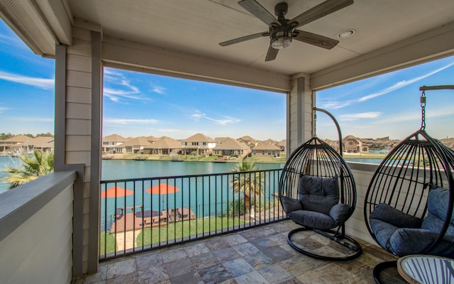 view of patio featuring a residential view, a balcony, ceiling fan, and a water view