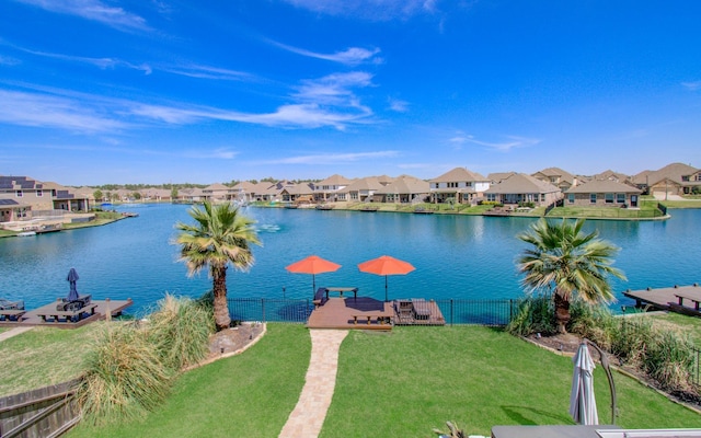 property view of water with a residential view, a boat dock, and fence