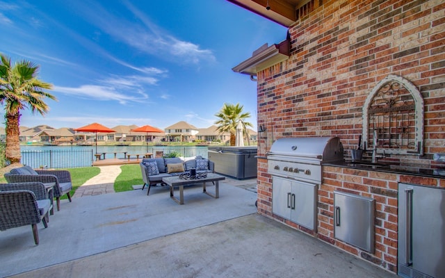 view of patio / terrace with a water view, area for grilling, a residential view, exterior kitchen, and outdoor lounge area