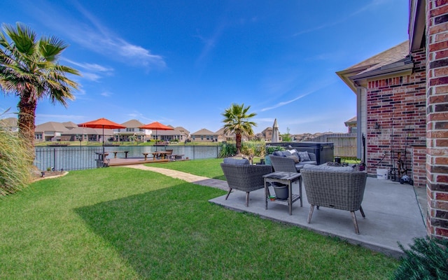 view of yard featuring a residential view, a water view, a patio, and fence