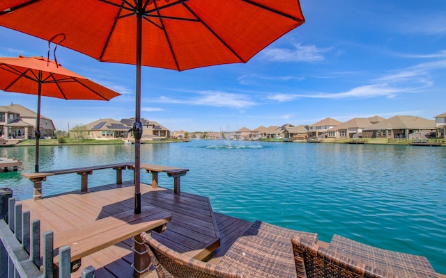 view of dock featuring a residential view and a water view