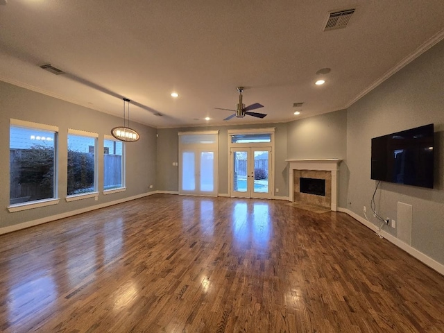 unfurnished living room featuring dark wood finished floors, crown molding, baseboards, and visible vents