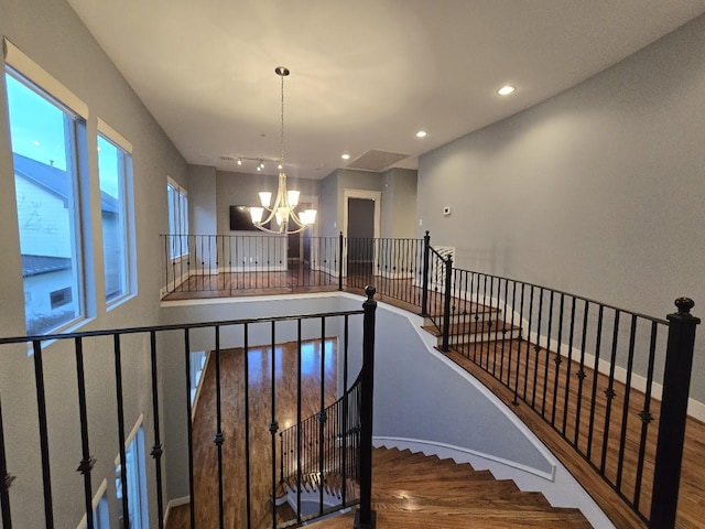 stairway with recessed lighting, baseboards, a chandelier, and wood finished floors