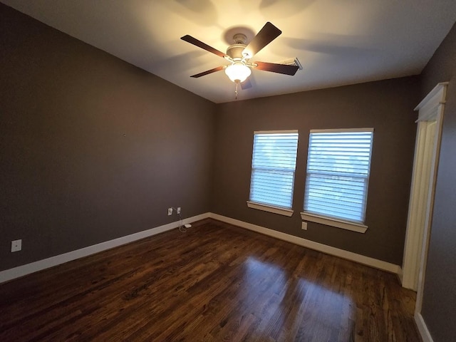 unfurnished bedroom featuring dark wood-type flooring, a ceiling fan, and baseboards