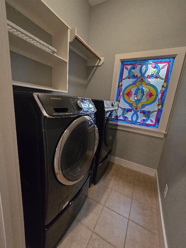 laundry room with laundry area, light tile patterned floors, baseboards, and independent washer and dryer