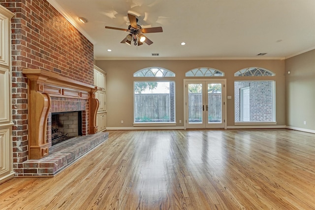 unfurnished living room with a brick fireplace, ornamental molding, light wood-style flooring, and ceiling fan