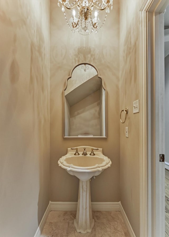 bathroom featuring baseboards and an inviting chandelier