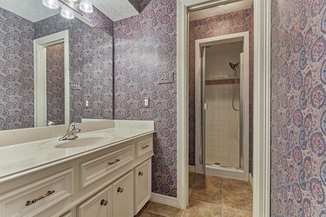 full bath with tile patterned floors, a textured ceiling, a shower stall, and wallpapered walls