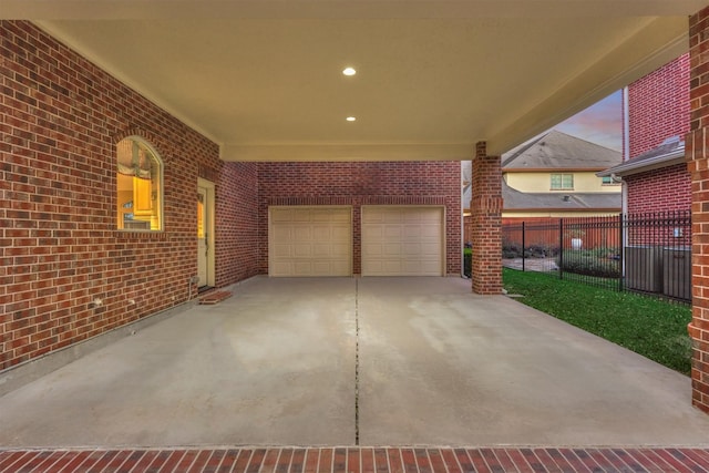 view of patio with concrete driveway, fence, and a garage