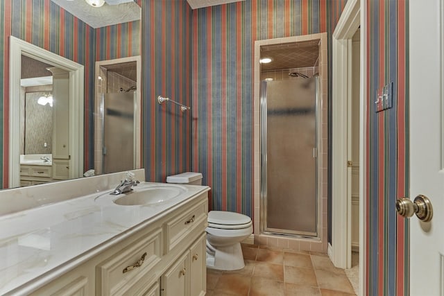 bathroom featuring vanity, toilet, a shower stall, and wallpapered walls