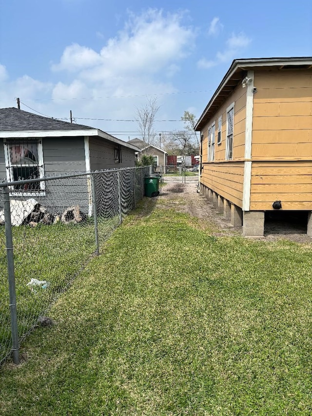 view of side of property with a lawn and fence