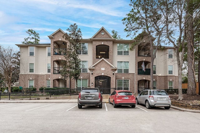 view of property featuring fence and uncovered parking