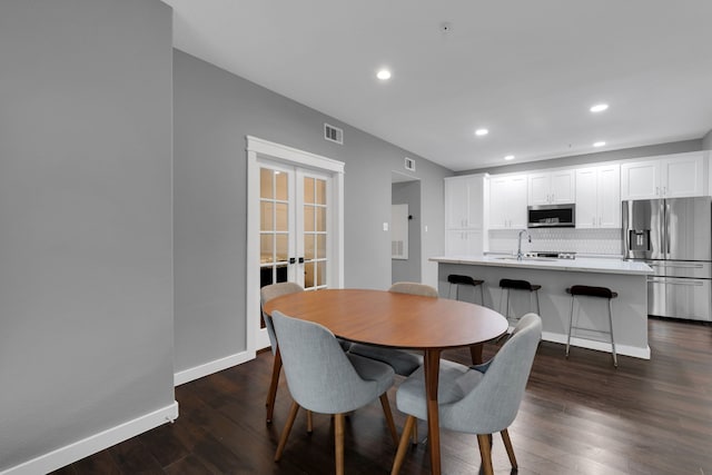 dining space featuring dark wood-style floors, visible vents, baseboards, recessed lighting, and french doors