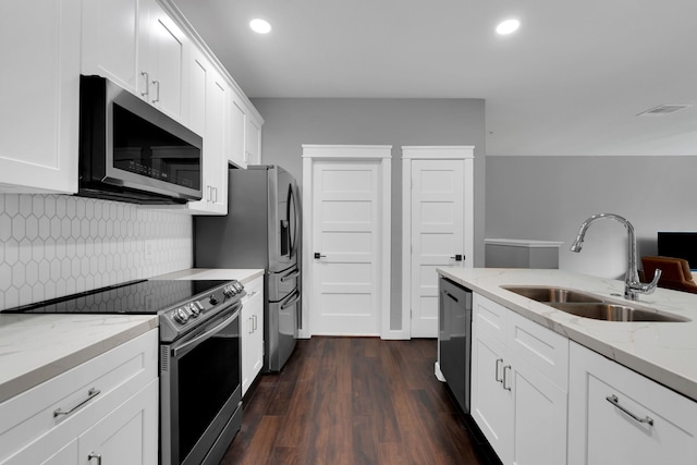 kitchen with a sink, light stone counters, backsplash, dark wood-style floors, and stainless steel appliances