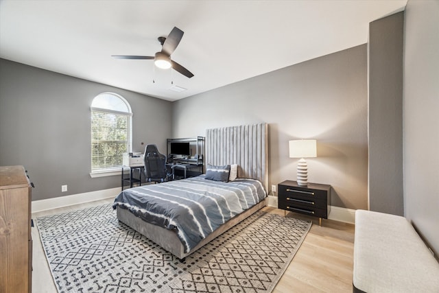 bedroom featuring visible vents, ceiling fan, baseboards, and wood finished floors