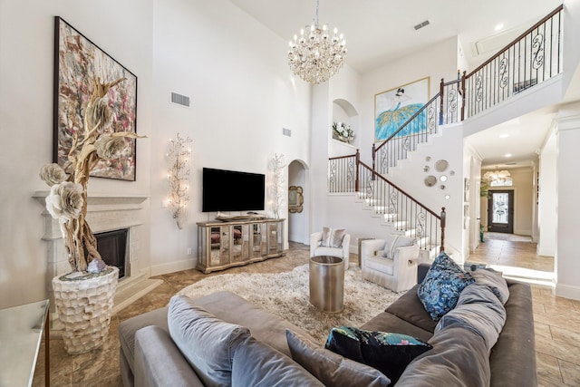 living area featuring arched walkways, visible vents, stairway, and a glass covered fireplace