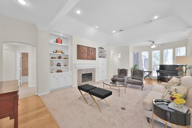 living room featuring visible vents, built in shelves, recessed lighting, a fireplace, and a ceiling fan