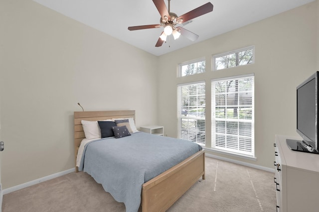 bedroom featuring baseboards, light carpet, and a ceiling fan