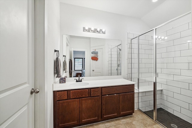 bathroom featuring tile patterned flooring, a stall shower, vanity, and lofted ceiling