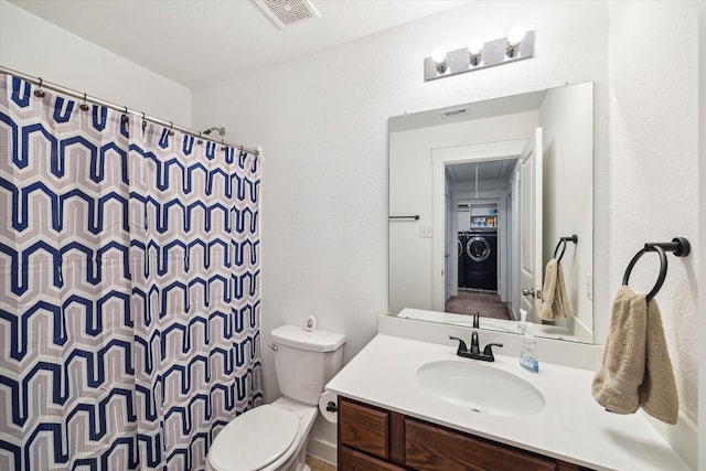 bathroom featuring vanity, a shower with shower curtain, visible vents, washer / dryer, and toilet