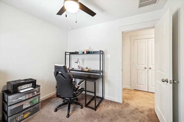 carpeted home office featuring visible vents, baseboards, and ceiling fan