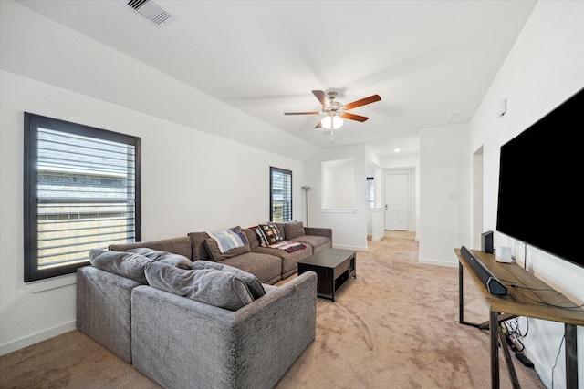 living area featuring visible vents, baseboards, light colored carpet, and a ceiling fan