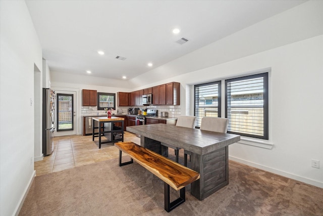 dining space with light tile patterned floors, visible vents, and light carpet