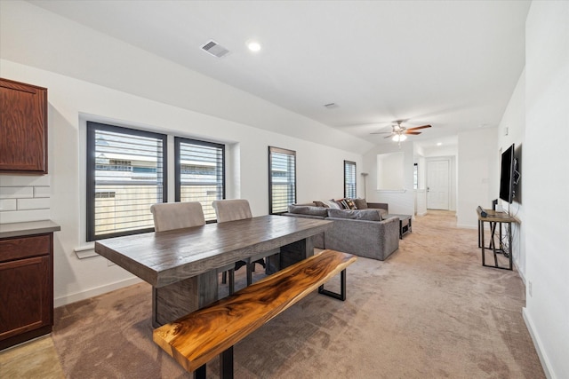 dining space featuring baseboards, light colored carpet, visible vents, and ceiling fan