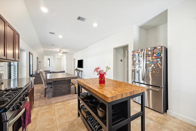 kitchen featuring a ceiling fan, visible vents, light tile patterned flooring, stainless steel appliances, and vaulted ceiling