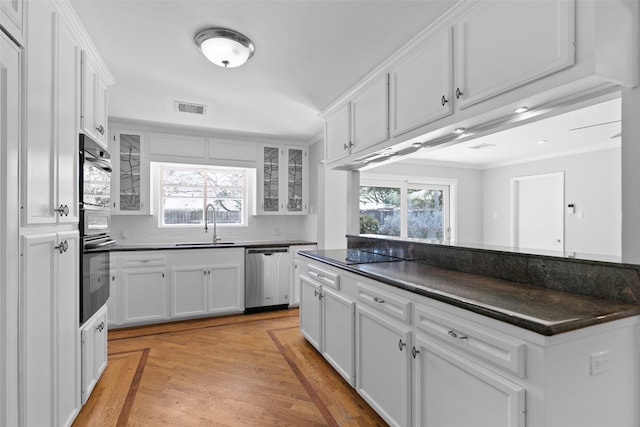 kitchen featuring black appliances, dark countertops, and visible vents