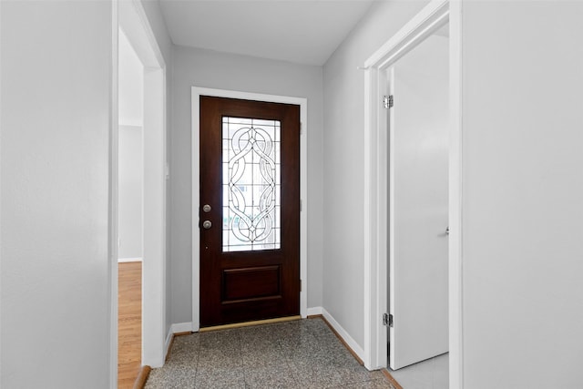 entryway with granite finish floor and baseboards