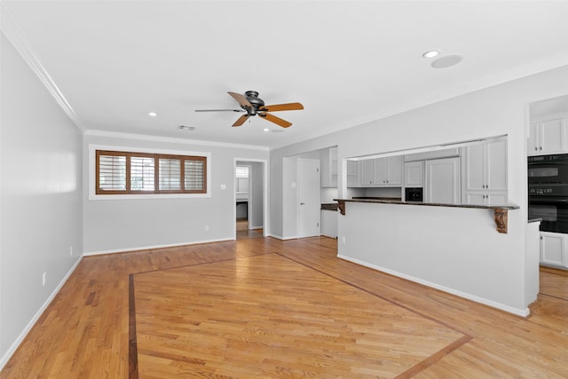 unfurnished living room with crown molding, baseboards, light wood-type flooring, and ceiling fan